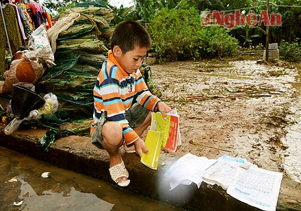 Em Nguyễn Bá Tuân bần thần bên đống sách vở ướt trũng.