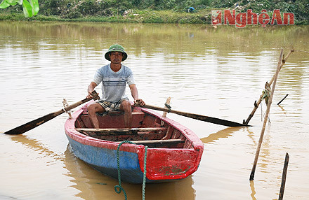 Anh Nguyễn Hữu Hoàng với chiếc thuyền nan đã cứu được hàng chục hộ dân trong đêm.
