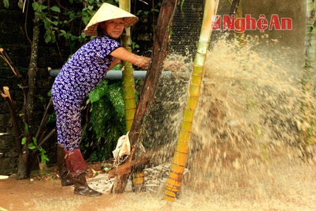 Bà Trần Thị Minh (khối 8, phường Mai Hùng) bơm nước trong nhà ra.