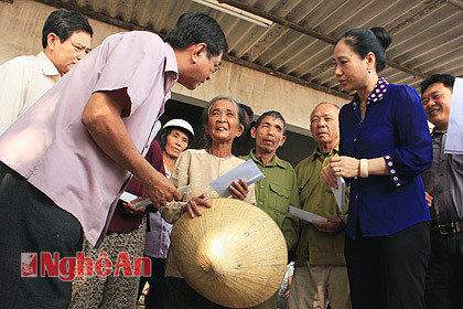 Đồng chí Đinh Thị Lệ Thanh - Phó Chủ tịch UBND tỉnh cùng đoàn công tác TP. Hồ Chí Minh trao tiền hỗ trợ cho người dân vùng lũ.