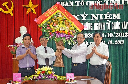 Đồng chí Trần Hồng Châu trao lẵng hoa chúc mừng tới cán bộ nhân viên Ban tổ chức Xây dựng đảng