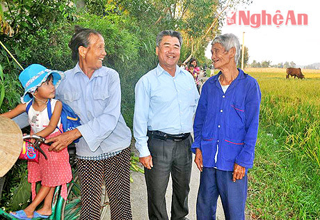 Ông Hoàng Văn Minh (ở giữa) trao đổi với bà con thôn 2 trên con đường liên xóm đang chuẩn bị được mở rộng.