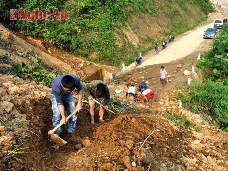 Nhiều người dân bản Tùng Hương tham gia đào đất mở đường tạm. 