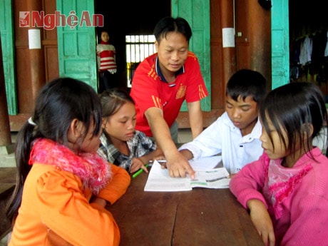 Thầy giáo hướng dẫn học sinh làm bài tập.