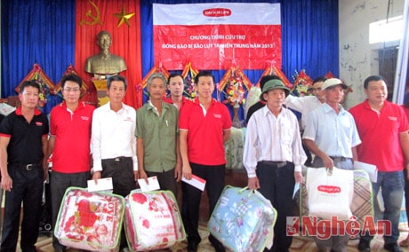 Ông Đào Quốc Trung, Trợ lý của Phó Tổng Giám đốc, cùng lãnh đạo của Công ty Bảo hiểm nhân thọ Dai Ichi Việt Nam trao quà cho các hộ gia đình bị ngập lụt ở xã Quỳnh Vinh, thị xã Hoàng Mai.