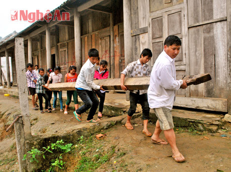 Thầy trò cùng cưa gỗ và khiêng đi dựng nhà.