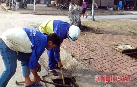 Công nhân Cty CP Quản lý và phát triển hạ tầng đô thị Vinh khơi thông cống rãnh