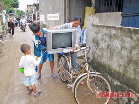 Chị Vũ Thị Hiền và cậu con trai chờ đồ đạc đi gửi