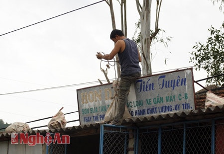 Chuyển bao cát lên nhà đề phòng gió lớn tốc mái ở khối 14, phường Quỳnh Xuân, thị xã Hoàng Mai