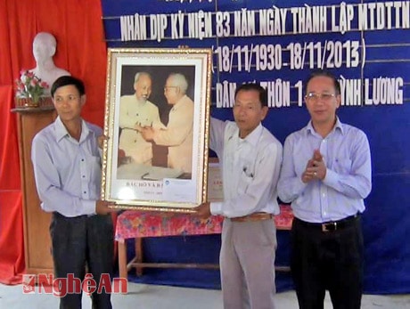 Đồng chí Trần Hồng Châu trao tặng bức ảnh Bác Hồ và Bác Tôn cho bà con thôn 1