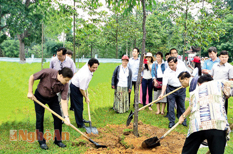 Thứ trưởng Bộ Tài chính Lào (áo sẫm) cùng lãnh đạo tỉnh trồng cây Lưu niệm tại Khu di tích Kim Liên tháng 8/2013. Ảnh: Văn Hải