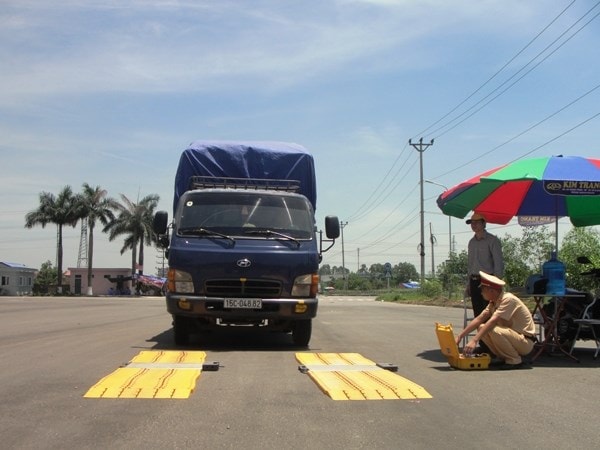 Lực lượng chức năng tiến hành cân tải trọng phương tiện trên các tuyến đường. (Ảnh: Việt Hùng/Vietnam+)
