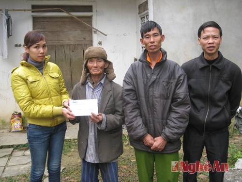 Đại diện Báo Nghệ An trao quà cho gia đình ông Nguyễn Đình Thai trước sự chứng kiến của đại diện cán bộ chính sách xã Xuân Sơn (Đô Lương)