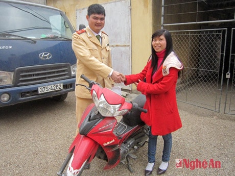 Thượng úy Chu Hồ Đức Dũng, CA huyện Quỳnh Lưu  trao xe cho chị Chuyên.