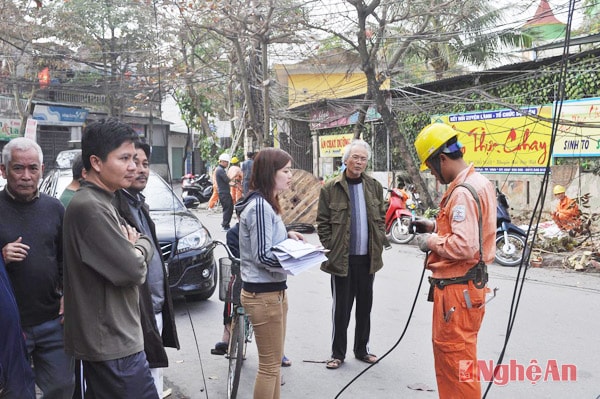 Người dân phối hợp với cán bộ ngành điện để xử lý lại việc đấu nối sau công tơ điện.