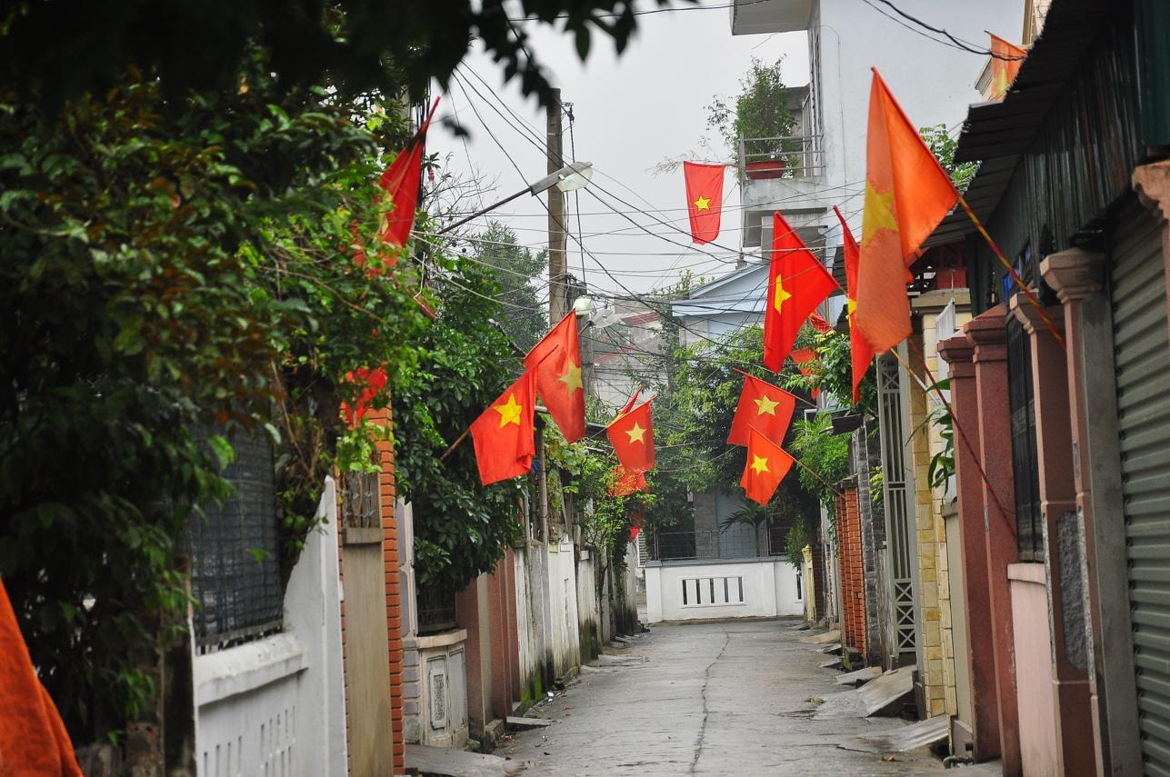 Ngõ nhỏ ở đường Hà Huy Tập vẫn ngủ yên, chỉ có sắc cờ đỏ bừng lên sáng rỡ