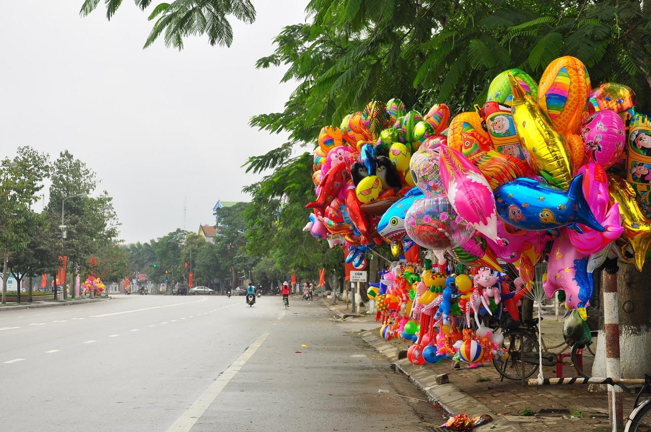 Nhưng dãy hàng bóng bay, quà Tết cho trẻ em, mở sớm lấy lộc đầu năm là điểm nhấn sắc màu cho thành Vinh một sáng tĩnh lặng hiếm hoi đầu năm   