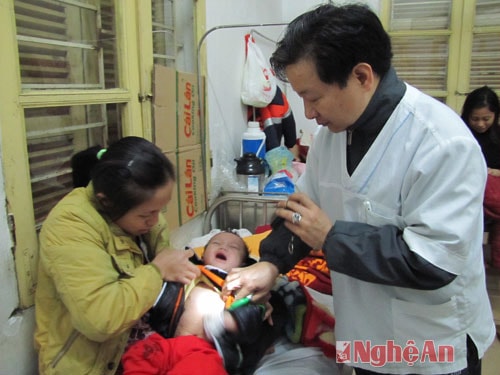 Bác sĩ kiểm tra một em bé bị mắc bệnh sởi đang điều trị ở Khoa truyền nhiễm.