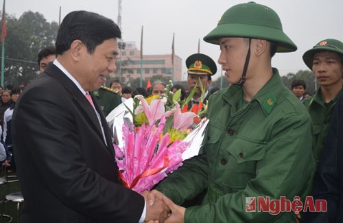 Lãnh đạo Quân khu và lãnh đạo tỉnh tặng hoa cho các tân binh.