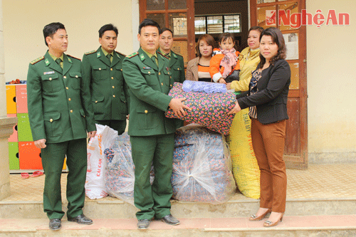 Tặng hàng trăm suất quà cho các gia đình nghèo và các em học sinh trên địa bàn. Trong ảnh, Đồn 527 trao chăn ấm cho HS trường mầm non xã Bắc Lý- Kỳ Sơn