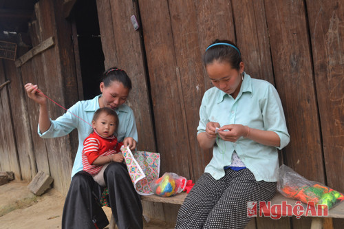 Phụ nữ Môngkhóe léo  thêu váy áo cho con trong nắng sáng mai