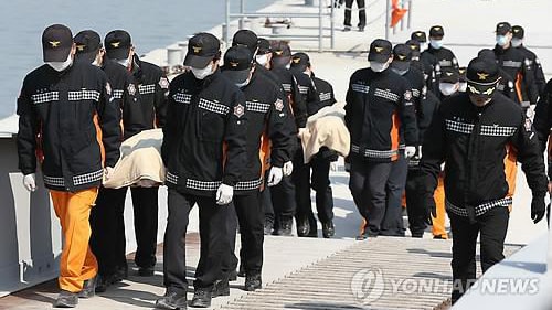 Nhân viên cảnh sát đưa thi thể của nạn nhân vừa tìm thấy từ chiếc phà Sewol bị đắm (Ảnh: Yonhap)