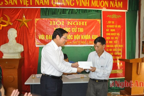 Đồng chí Phan Đình Trạc trao quà tặng của Đoàn đại biểu QH Nghệ An cho lãnh đạo xã Bảo Nam