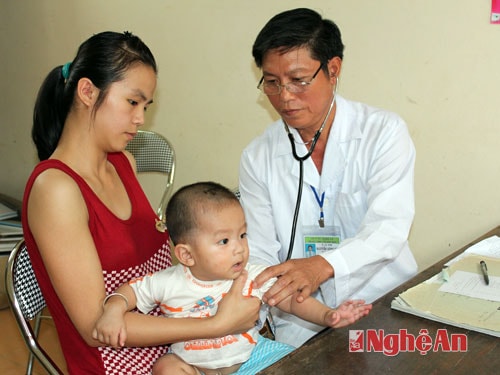 Khám sàng lọc trước tiêm phòng cho trẻ tại Trạm y tế xã Cẩm Sơn (Anh Sơn).