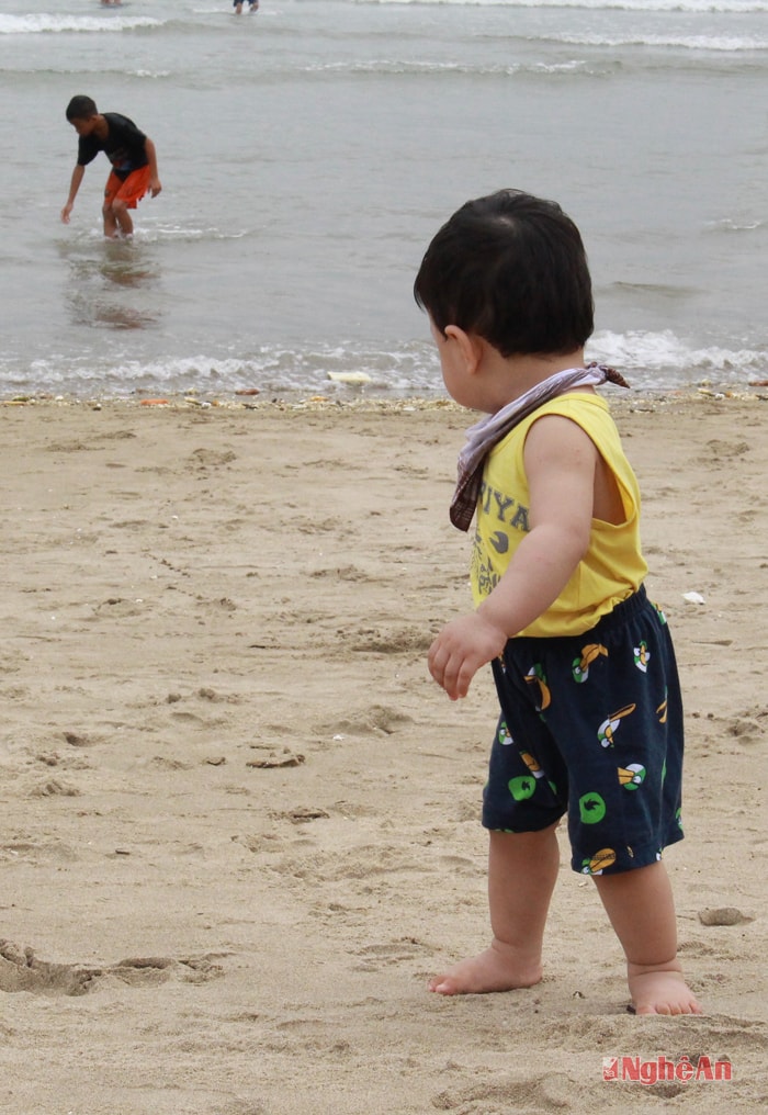 Em bé chậchp ững bước trên bãi cát mịn.