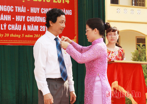 Đồng chí Nguyễn Thị Kim Chi - Phó Giám đốc Sở GD&ĐT thừa ủy quyền trao Huân chương Lao động hạng Ba cho thầy Lê Ngọc Hùng.