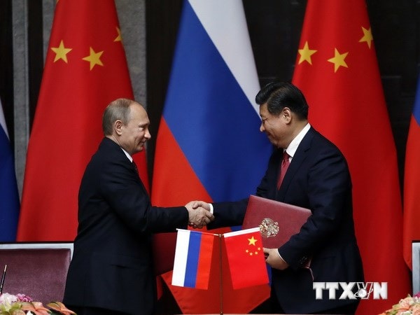 Chủ tịch Trung Quốc Tập Cận Bình và Tổng thống Nga Vladimir Putin trao đổi một thỏa thuận hợp tác trong cuộc hội đàm song phương ở Thượng Hải. (Nguồn: AFP/TTXVN)