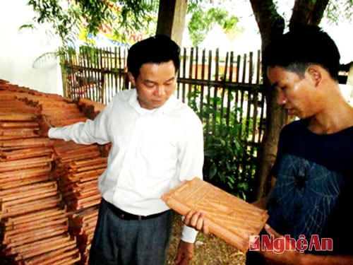 Anh Lộc Văn Việt (trái) trao ngói hỗ trợ hộ nghèo tại bản Piềng Khử.