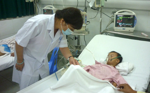 Bộ trưởng Y tế Nguyễn Thị Kim Tiến khảo sát tình hình dịch bệnh tại BV Nhi TƯ tối 25/6. Trong ảnh là bệnh nhân Trần Hữu Hùng Vĩ (2 tuổi, quê Thái Bình) bị viêm não - Ảnh: Cẩm Quyên