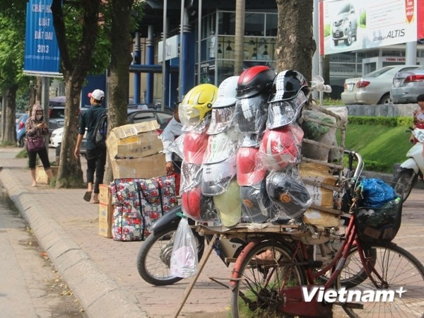 Hàng bán mũ kém chất lượng trên vỉa hè vẫn còn lác đác dù sát ngày xử phạt. (Ảnh: Việt Hùng/Vietnam+)