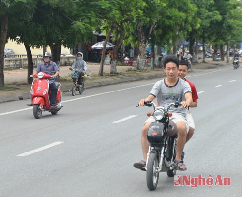 Nhiều học sinh, sinh viên sử dụng xe đạp điện lưu thông trên đường cũng không tuân thủ quy định đội mũ bảo hiểm đúng chuẩn