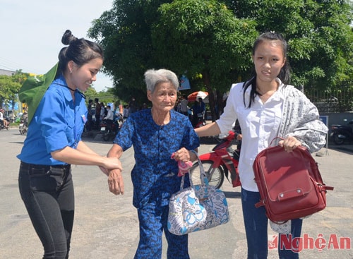 Tại điểm thi Trường Đại học Vinh, cụ bà gần 80 tuổi đưa cháu đi thi bị mệt và nhận được sự giúp đỡ của các thanh niên tình nguyện.