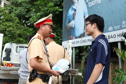 Cảnh sát giao thông Hà Nội tuyên truyền, nhắc nhở người dân đội mũ bảo hiển không đạt chuẩn.