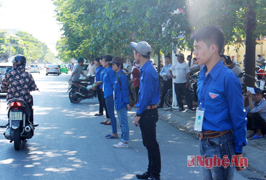 Các sinh viên tình nguyện đứng xếp hàng phân luồng giao thông trên đường Lê Hồng Phong
