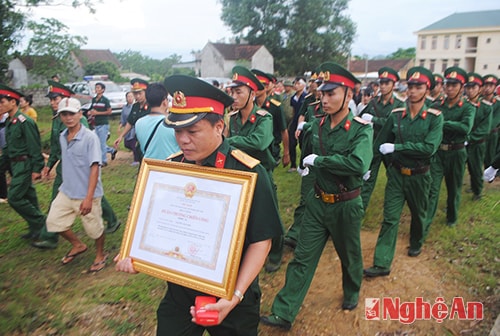 Người dân và các đồng chí, đồng nghiệp đưa anh về Đài tưởng niệm liệt sỹ - xã nhà nơi diễn ra lễ truy điệu