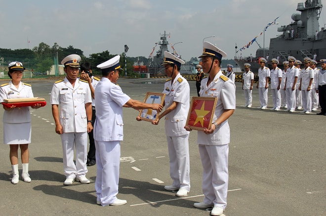 Đại tá Lương Việt Hùng, Tư lệnh vùng 2 trao quốc kỳ và hải kỳ cho thuyền trưởng, chính trị viên 2 tàu pháo tên lửa.