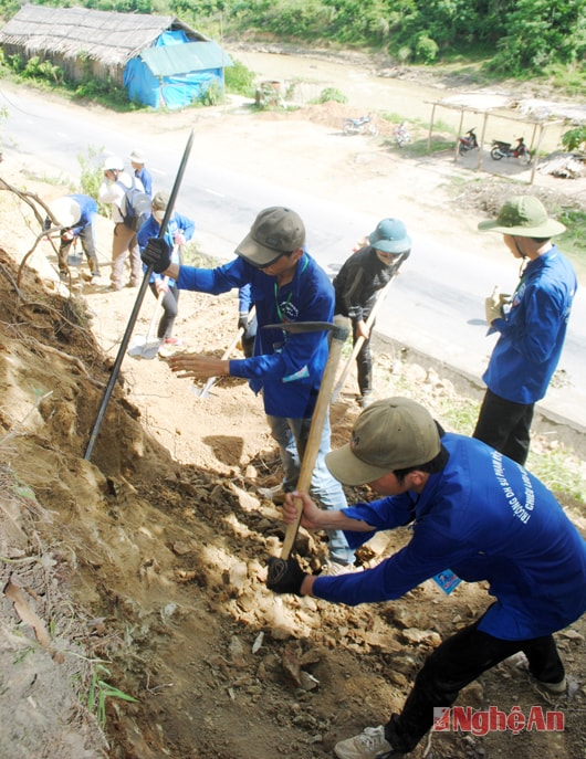 Sinh viên tình nguyện Trường Đại học SPKT Vinh giúp dân bản Khe Tang, Chiêu Lưu, Kỳ Sơn mở rộng đường. Ảnh: H.P