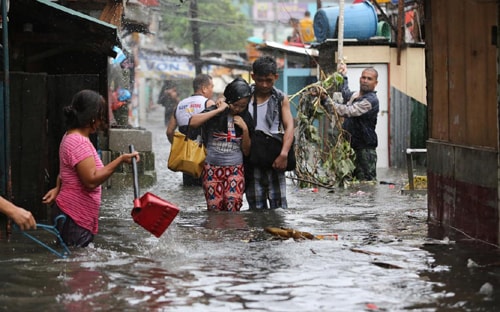 Người dân bì bõm lội đi trong khu vực ngập nước do ảnh hưởng bão Rammasen (ảnh: Reuters)