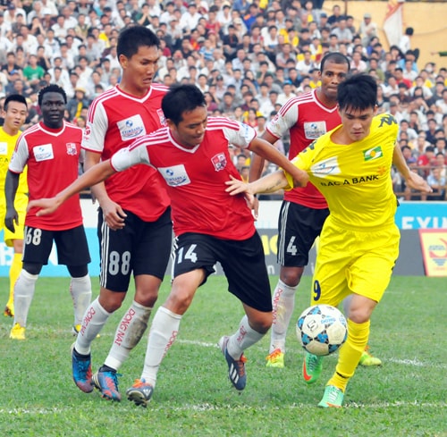 Các cầu thủ Đồng Nai (áo sẫm) trong trận đấu lượt đi V.League 2014 trên sân Vinh.