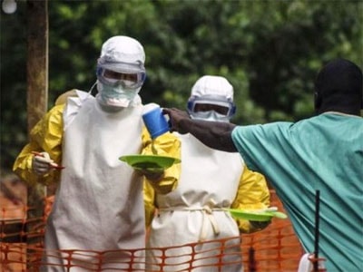 Nhân viên y tế mang đồ ăn cho bệnh nhân Ebola ở khu vực bị cách ly. Ảnh: Reuters.