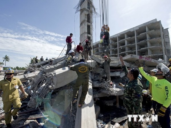 Nhân viên cứu hộ làm việc tại hiện trường vụ sập nhà. (Nguồn: AFP/TTXVN)