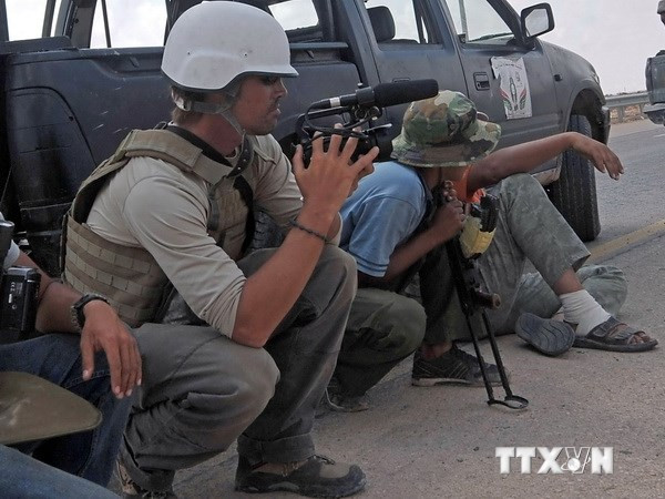 Phóng viên Mỹ James Foley (trái) trên tuyến đường cao tốc giữa sân bay và cửa ngõ phía tây thành phố Sirte, Libya ngày 29/9/2011. (Nguồn: AFP/TTXVN)