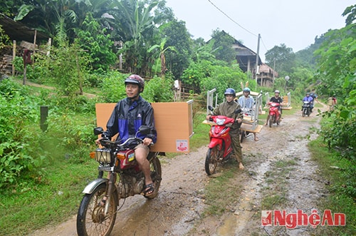 Các thầy cô ở trường tiểu học Xiêng My chở bàn ghế, dụng cụ học tập do Báo Nghệ An tặng cho các em học sinh