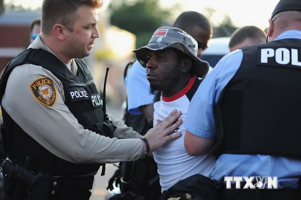 Cảnh sát tạm giữ một người biểu tình quá khích ở đại lộ Tây Florissant tại Ferguson, Missouri ngày 19/8. (Nguồn: AFP/TTXVN)