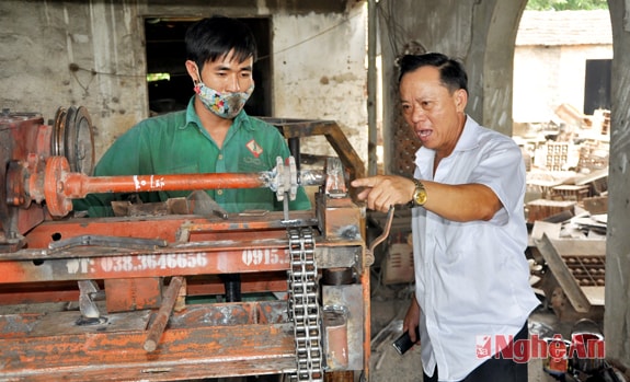 Ông Hồ Văn Hoàn, Giám đốc Công ty THHH Hồ Hoàn Cầu (phải) hướng dẫn  thợ thao tác chi tiết máy.