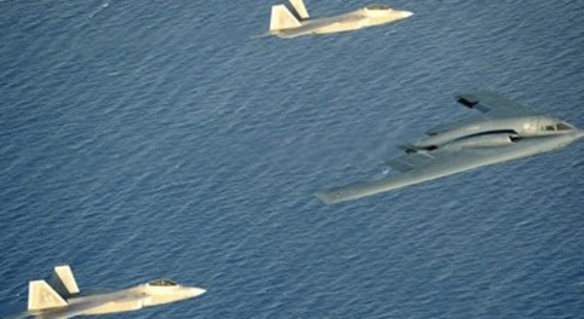 B-2 Spirit được hai chiếc tiêm kích tàng hình F-22 hộ tống tại Guam. Ảnh: US Nav
